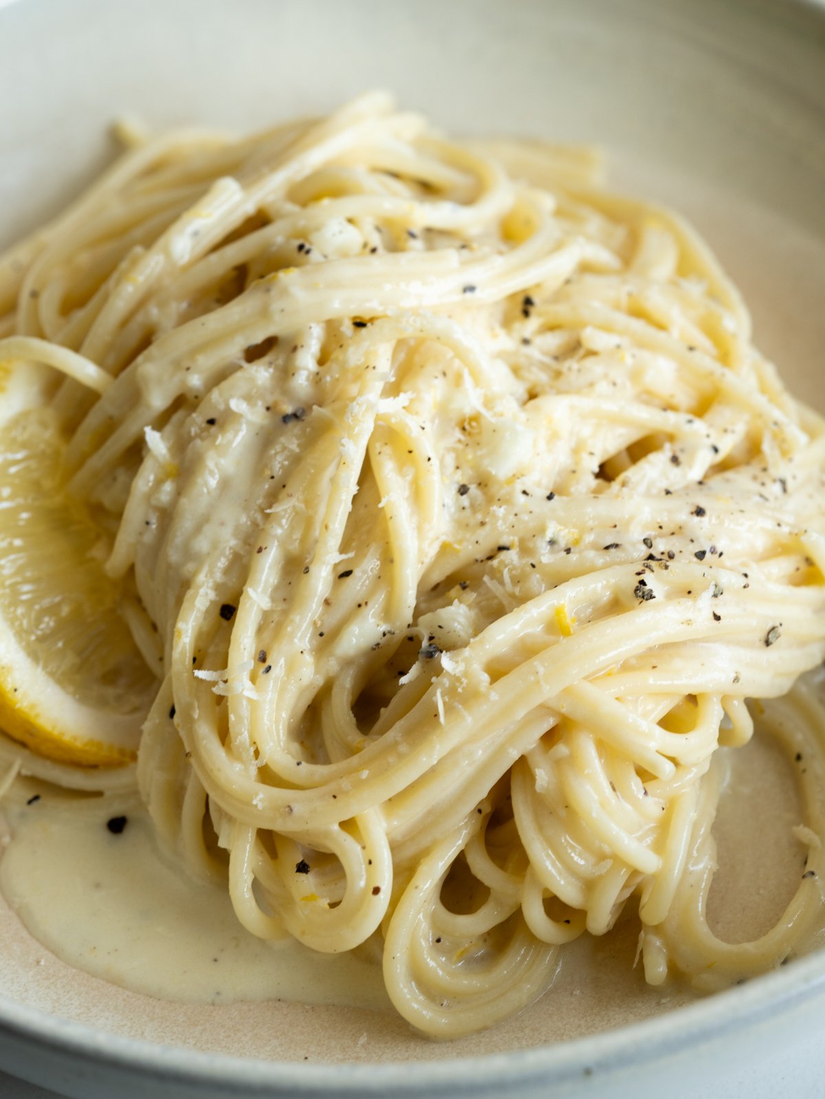 pasta in a creamy lemon sauce served with a sprinkle of black pepper and more parmesan.