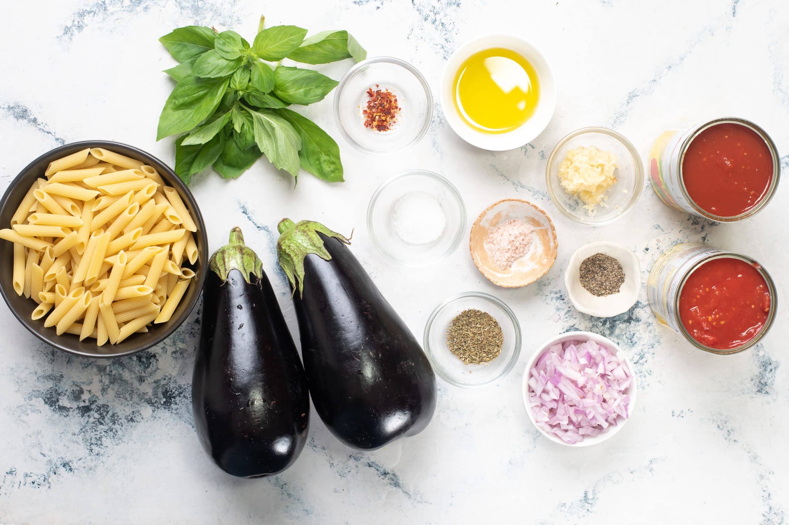 Ingredients to make Pasta Alla Norma - pasta, eggplant, cheese, basil, tomato as classic ingredients