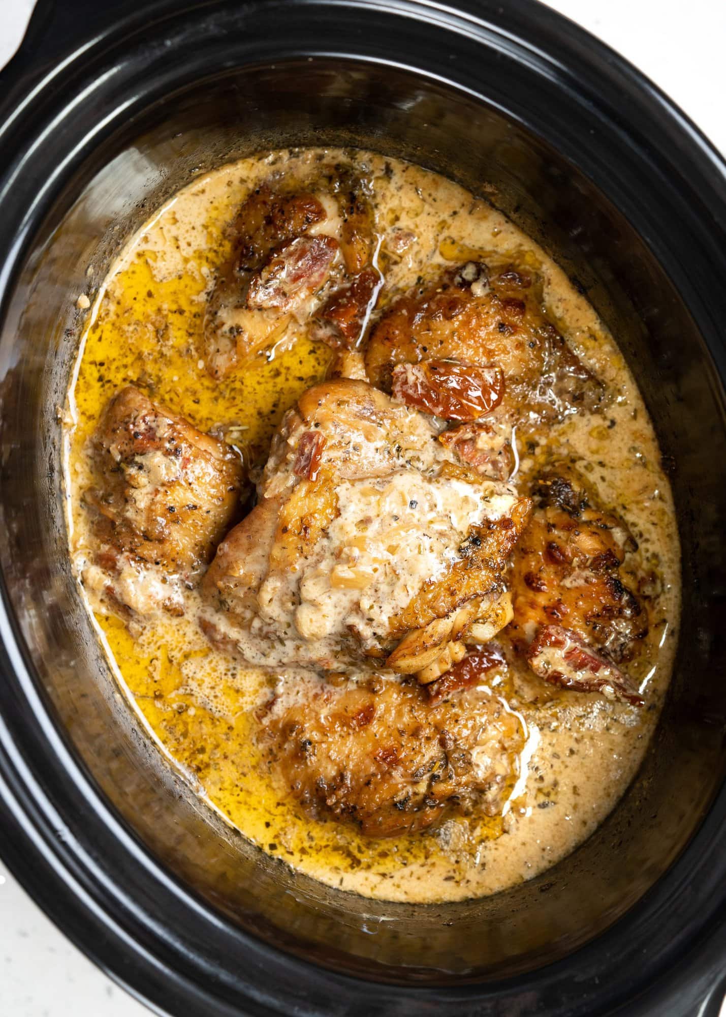 Seared crispy chicken thighs in a sun-dried tomato sauce, made in a slow cooker.