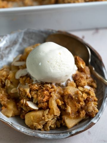 Apple crisp served with a scoop of ice cream