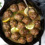 Baked meatballs in a butter garlic sauce on a skillet