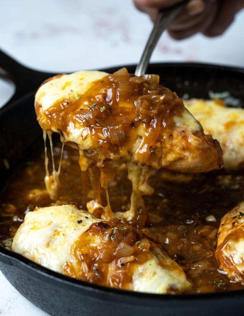 Picking up a chicken breast topped with cheese from this saucy caramelized onion gravy