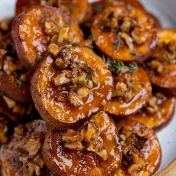 Sweet potatoes are made with a glaze from maple syrup and topped with crunchy walnuts. They have warmth from the cinnamon and herby flavors from thyme.