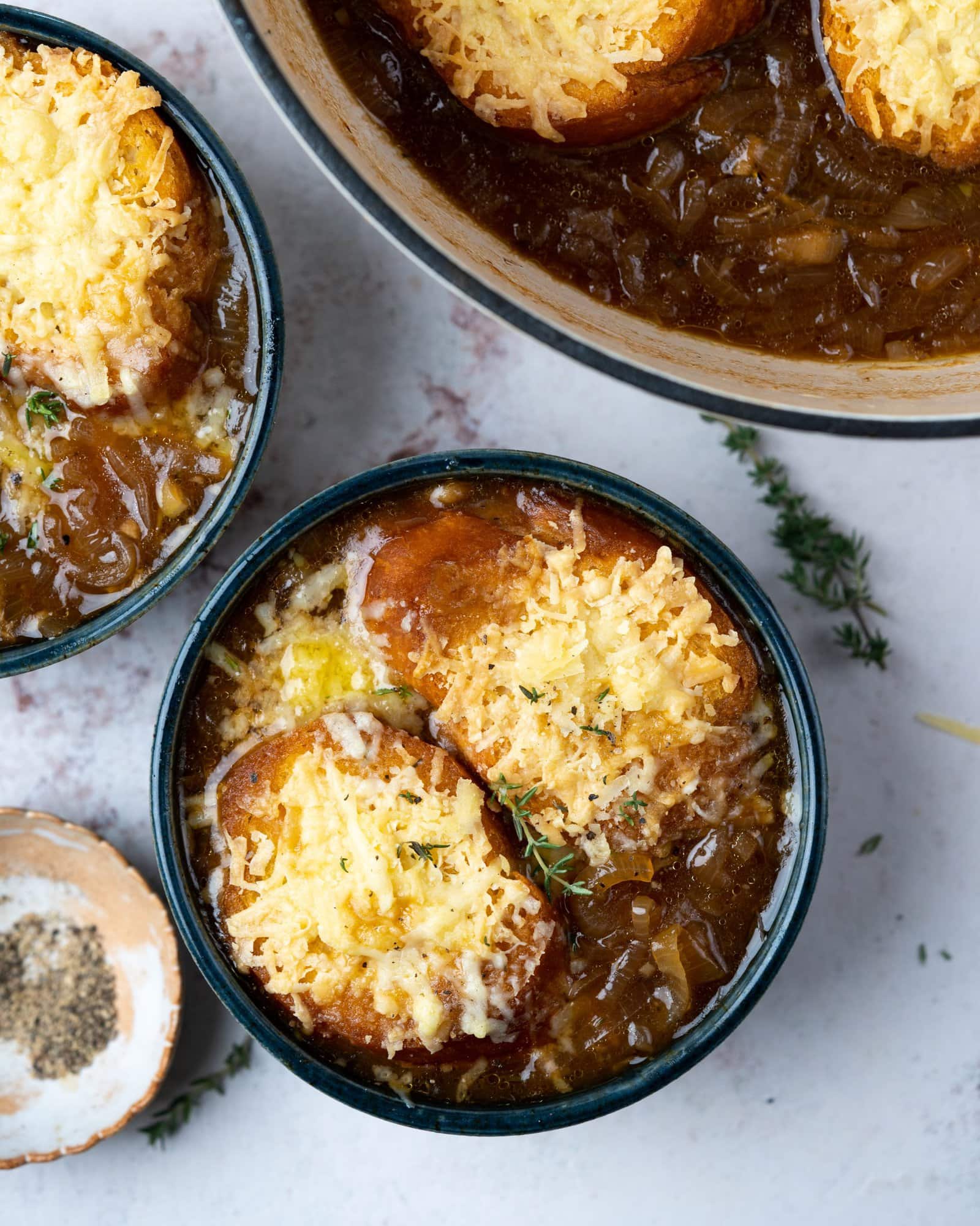 Bowl of french onion soup with cheese topped toasted bread.