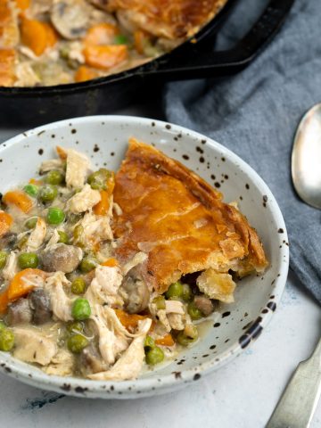 Savory filling of chicken and vegetables along with pie crust served in a bowl