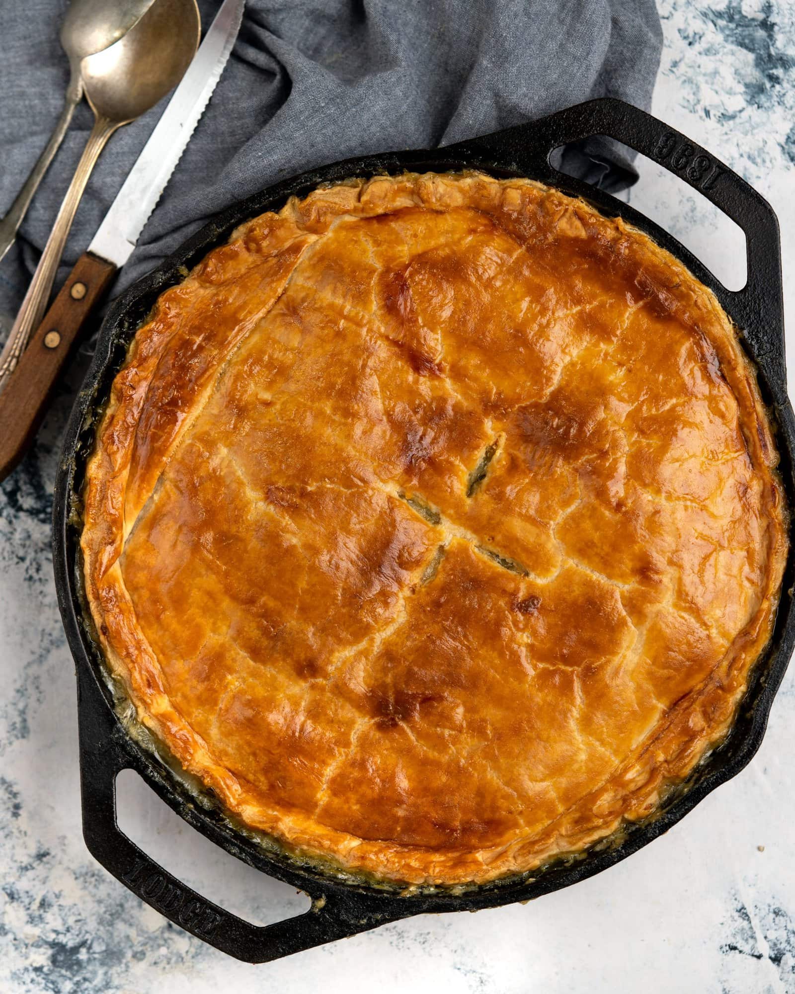 Flaky pastry on top of delicious chicken, mushroom and vegetable filling in Chicken Pot Pie, made in a cast iron skillet.
