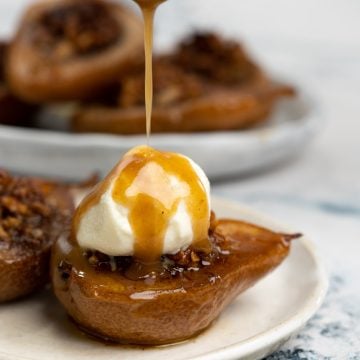 Caramelized sauce drizzled over ice cream placed on top of baked pear