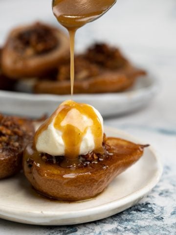 Caramelized sauce drizzled over ice cream placed on top of baked pear