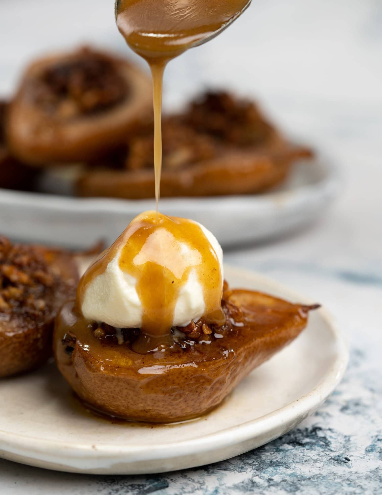 Caramelized sauce drizzled over ice cream placed on a baked pear
