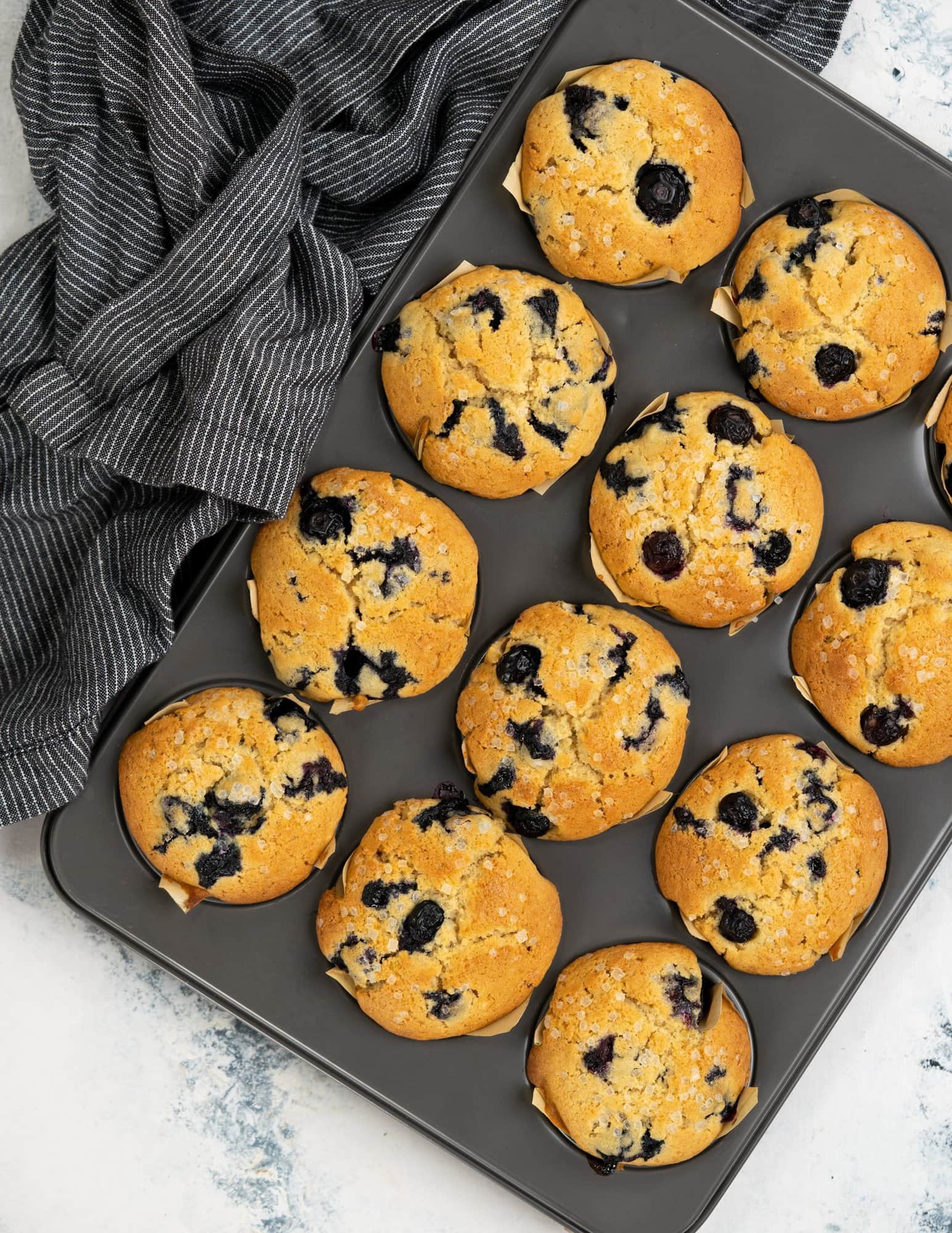 Baked blueberry muffins with crunchy sugar on top.