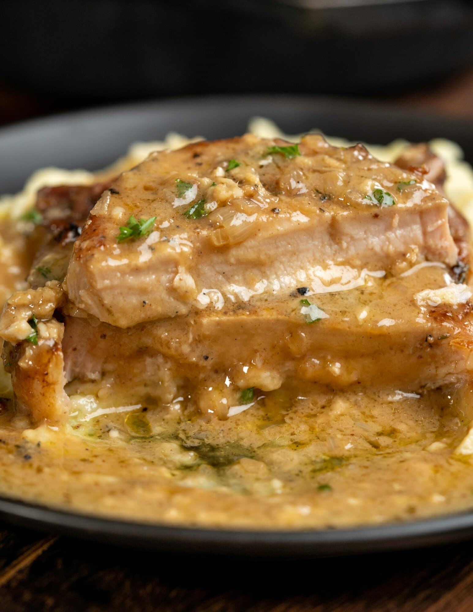 Light pink inside of cut pork chops, seared in a skillet and served with a sour cream gravy