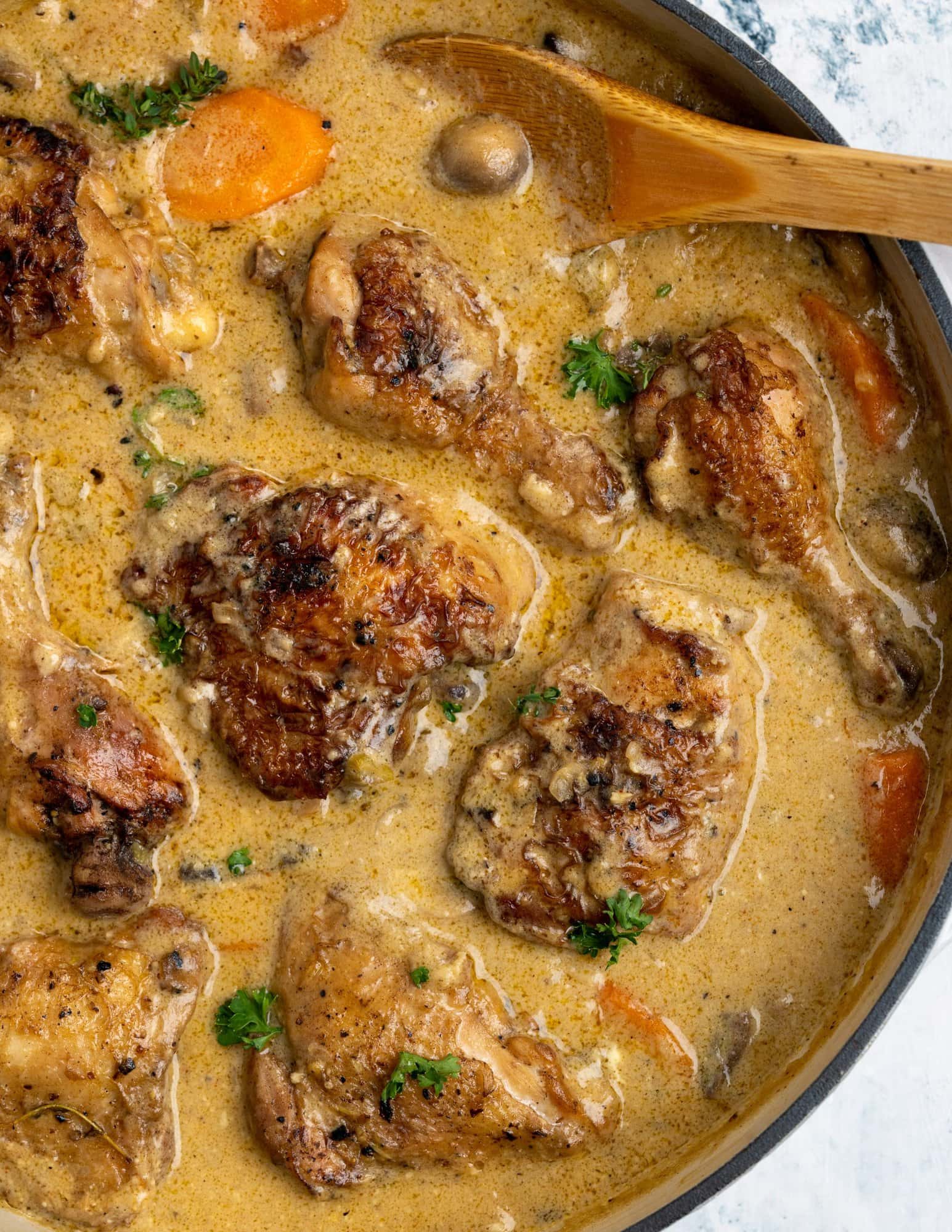 Seared and browned chicken pieces lying in a delicious and creamy sauce with flavors from mushroom and stock.