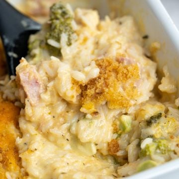 Close up view of leftover ham casserole having rice, ham, broccoli with a creamy and cheesy sauce along with crusty top.