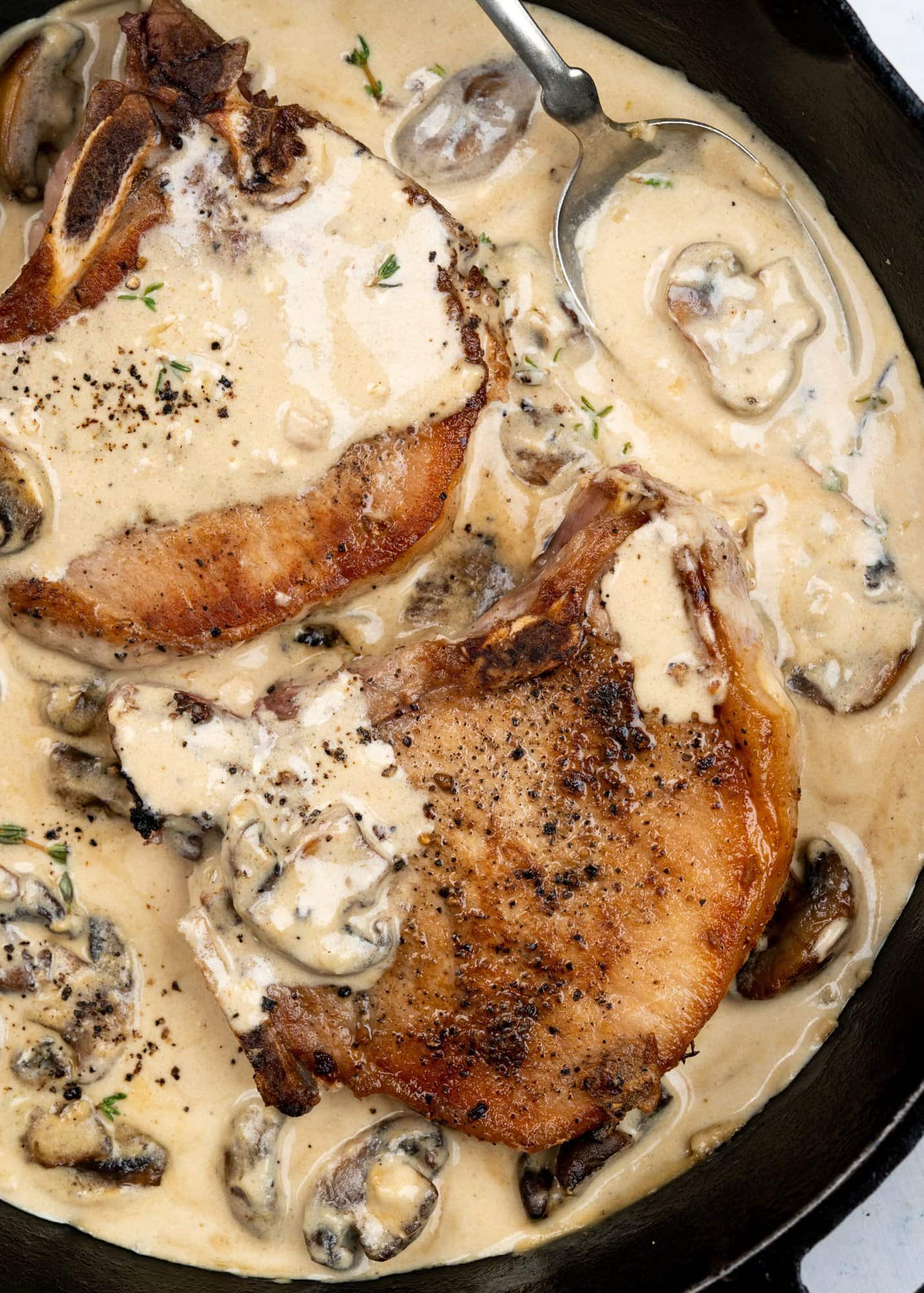 Seared pork chops with a nice crust and smothered with velvety and creamy mushroom sauce and made in a skillet.