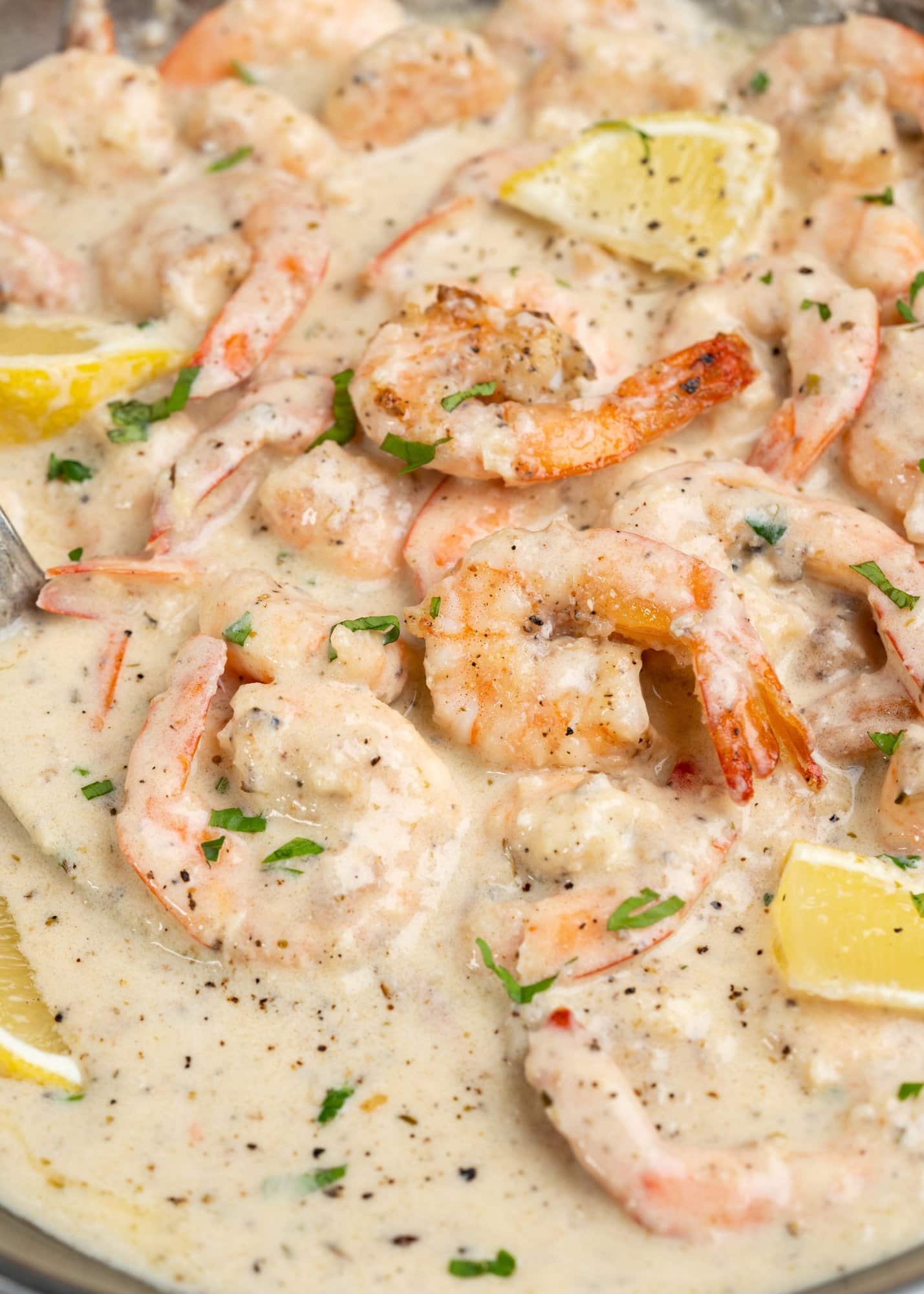 Shrimp coated with the creamy sauce and topped with some chopped fresh parsley and lemon slices.
