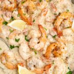 Top view of garlic shrimp in a creamy sauce having flavors from lemon juice, cream and parmesan