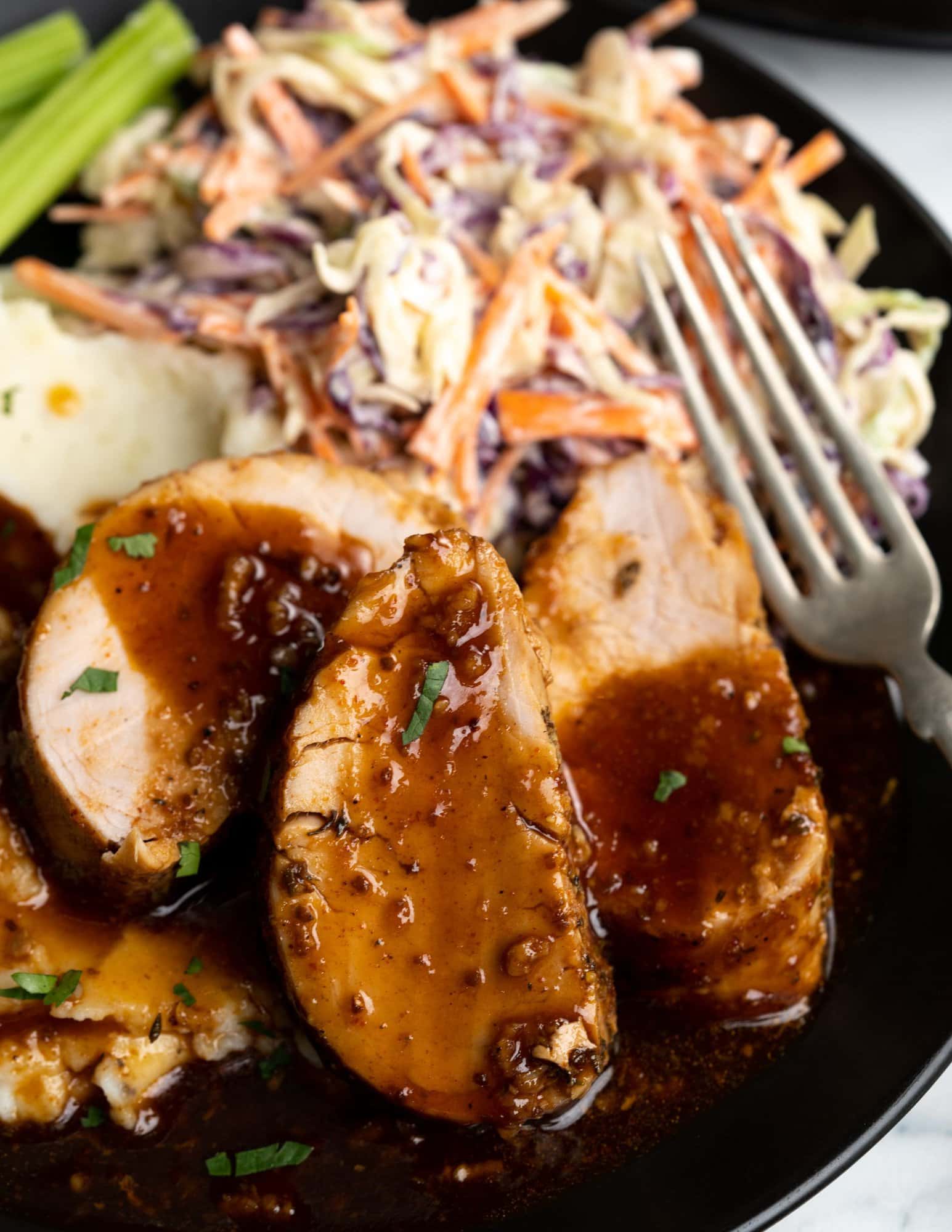 Baked pork Tenderlion glazed with bbq sauce served with some coleslaw