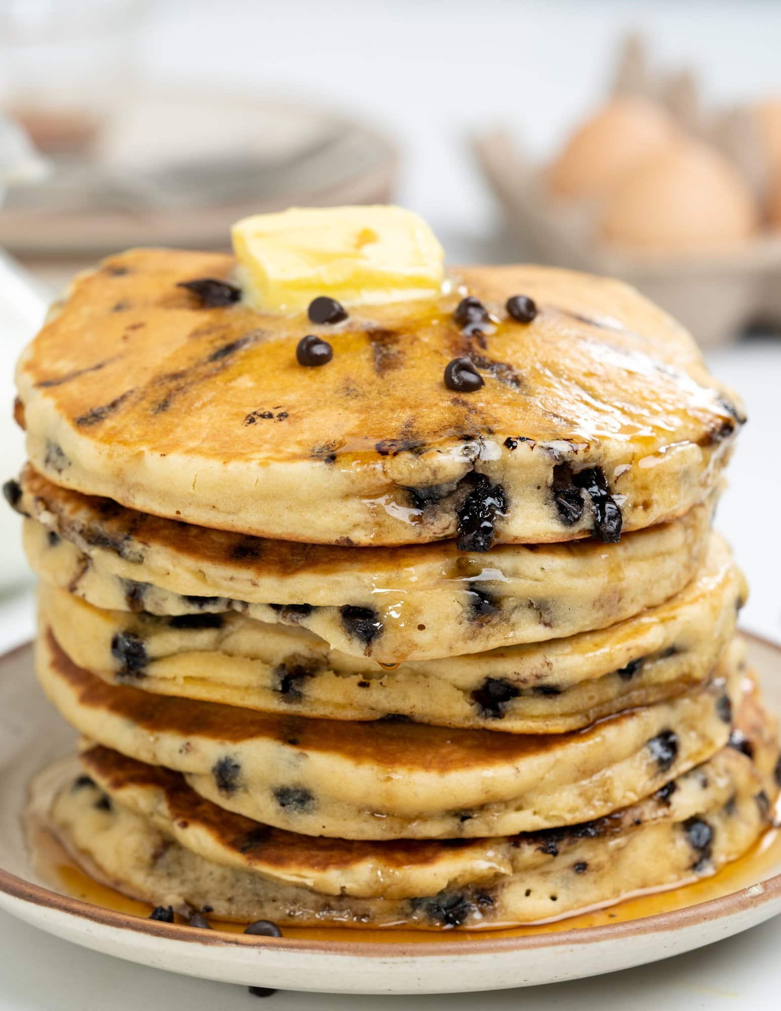 Stack of soft chocolate chip pancakes. loaded with chocolate chips and topped with butter.