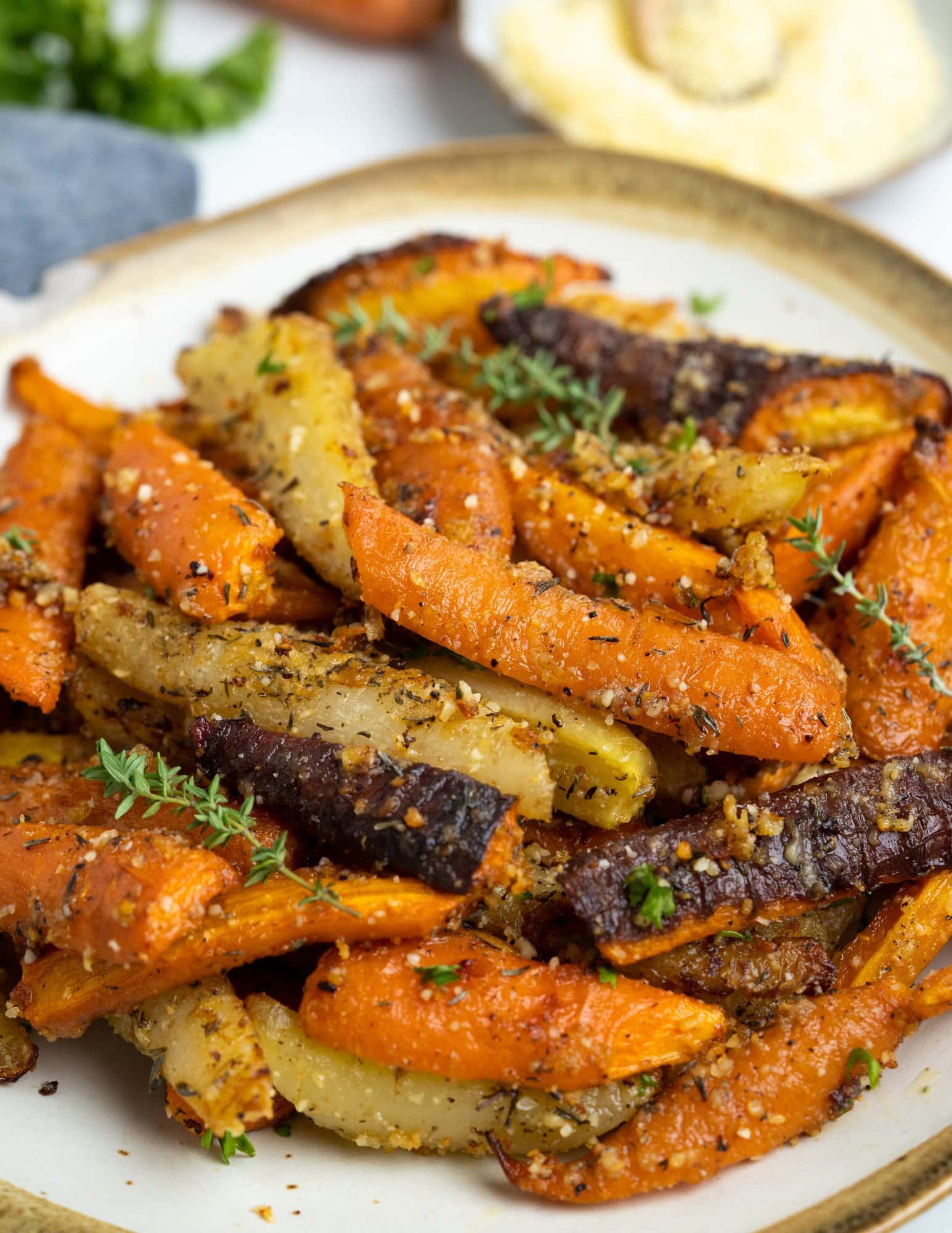Carrots tossed in butter, olive oil, garlic, herbs, and parmesan cheese makes the best ever roasted Carrots. The natural sweetness of the caramelized carrots complements the savory seasoning, making it one of our favourite side dishes. 
