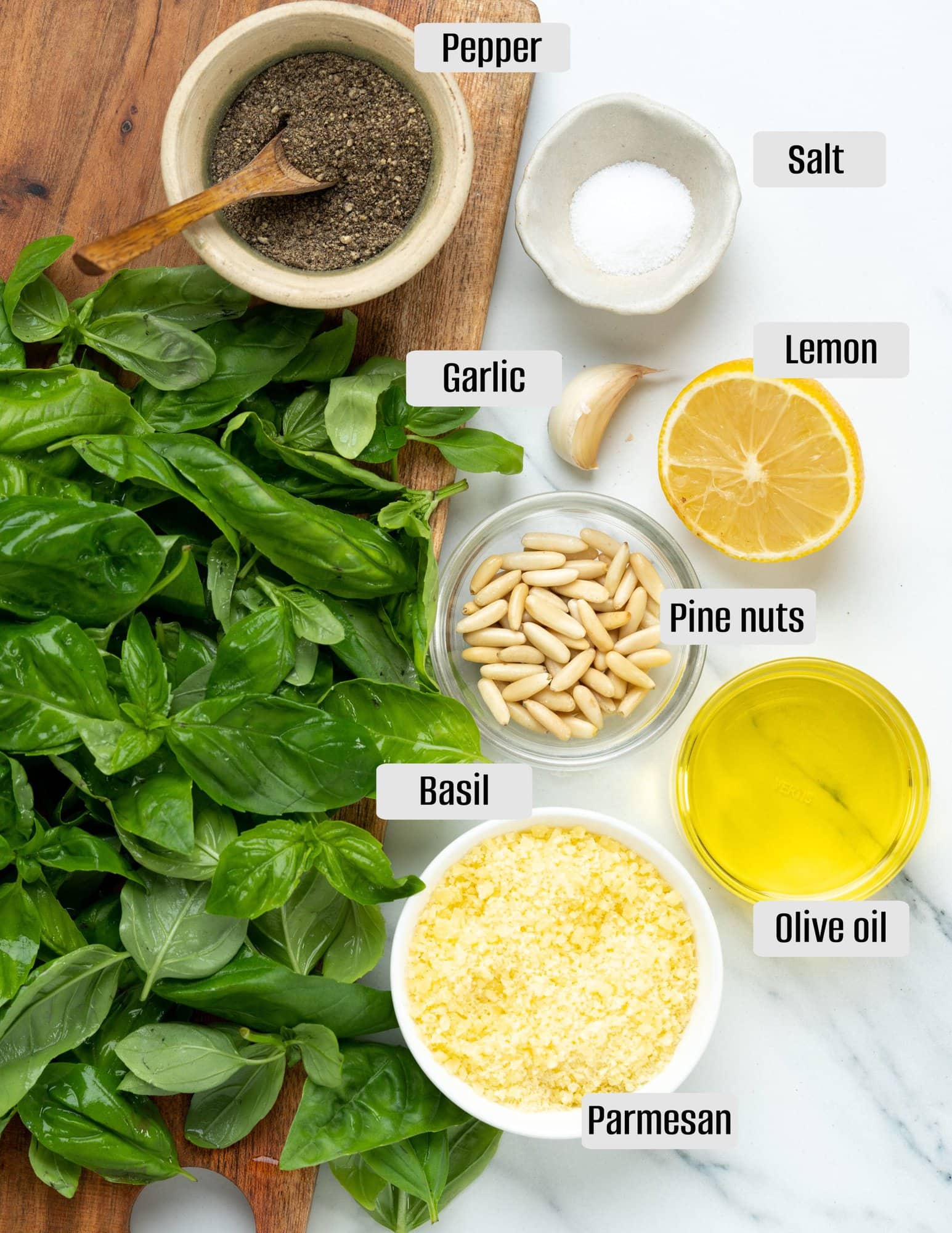 Ingredients for classic pesto sauce - basil, garlic, parmesan, olive oil, pine nuts, lemon juice, salt and pepper.