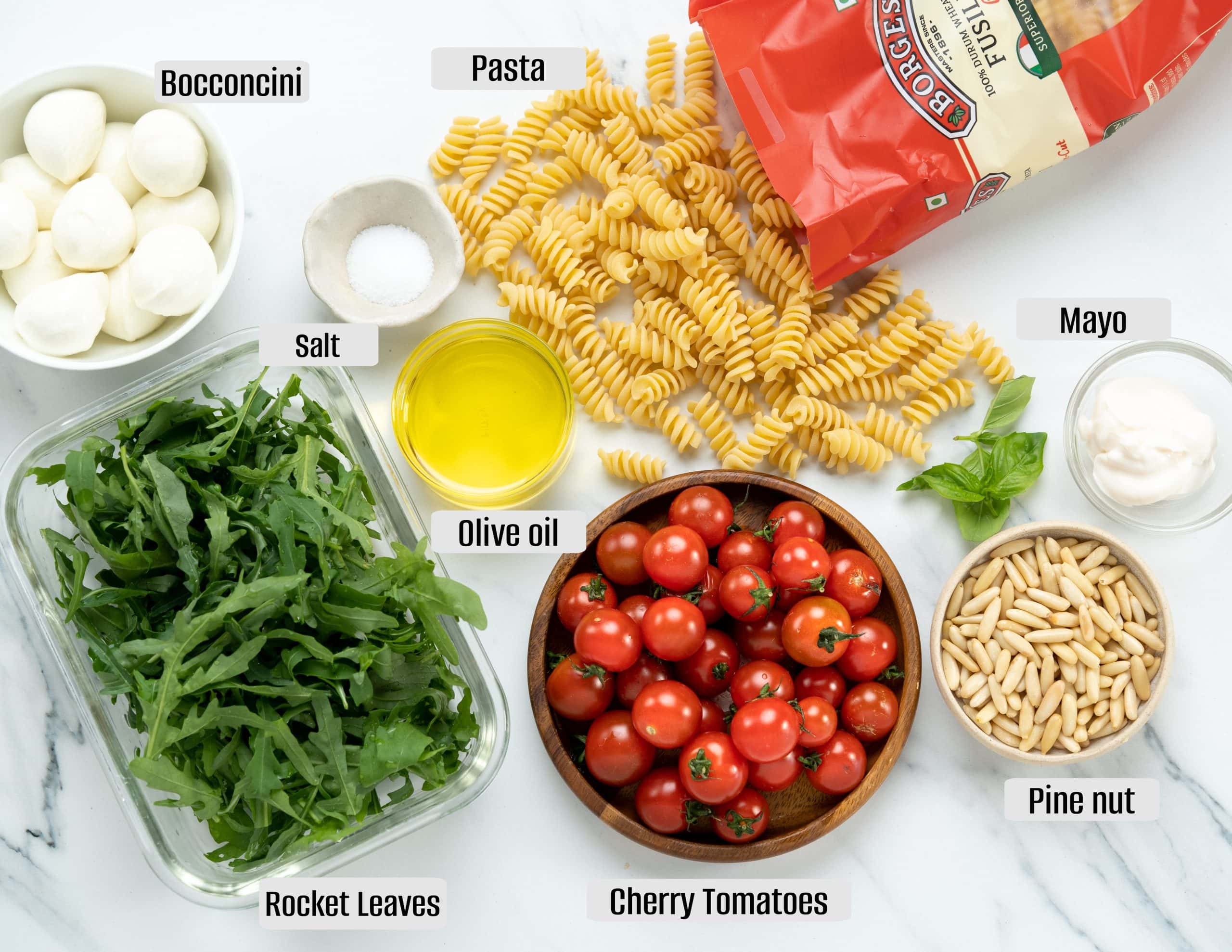 Pasta and other ingredients to make pesto pasta salad.