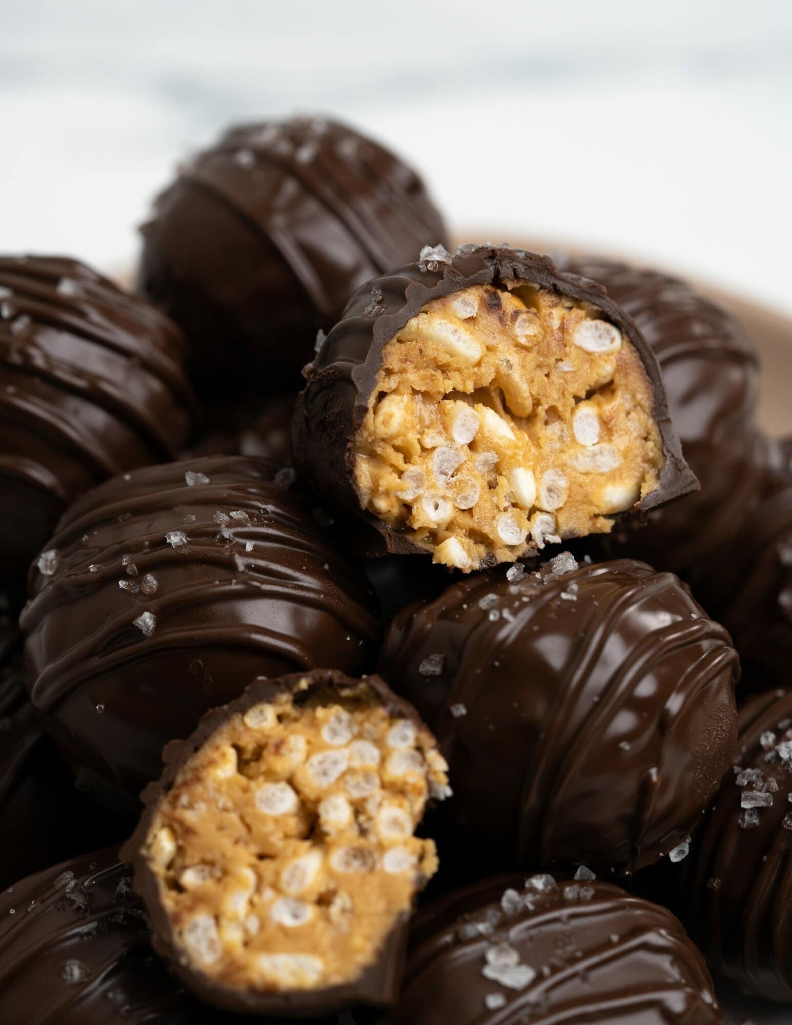 These no-bake Peanut butter balls are covered with dark chocolate and have crunch in every bite from the puffed rice cereal. Easy and fun to make peanut butter balls are perfect sweet treats for kids and adults alike. 