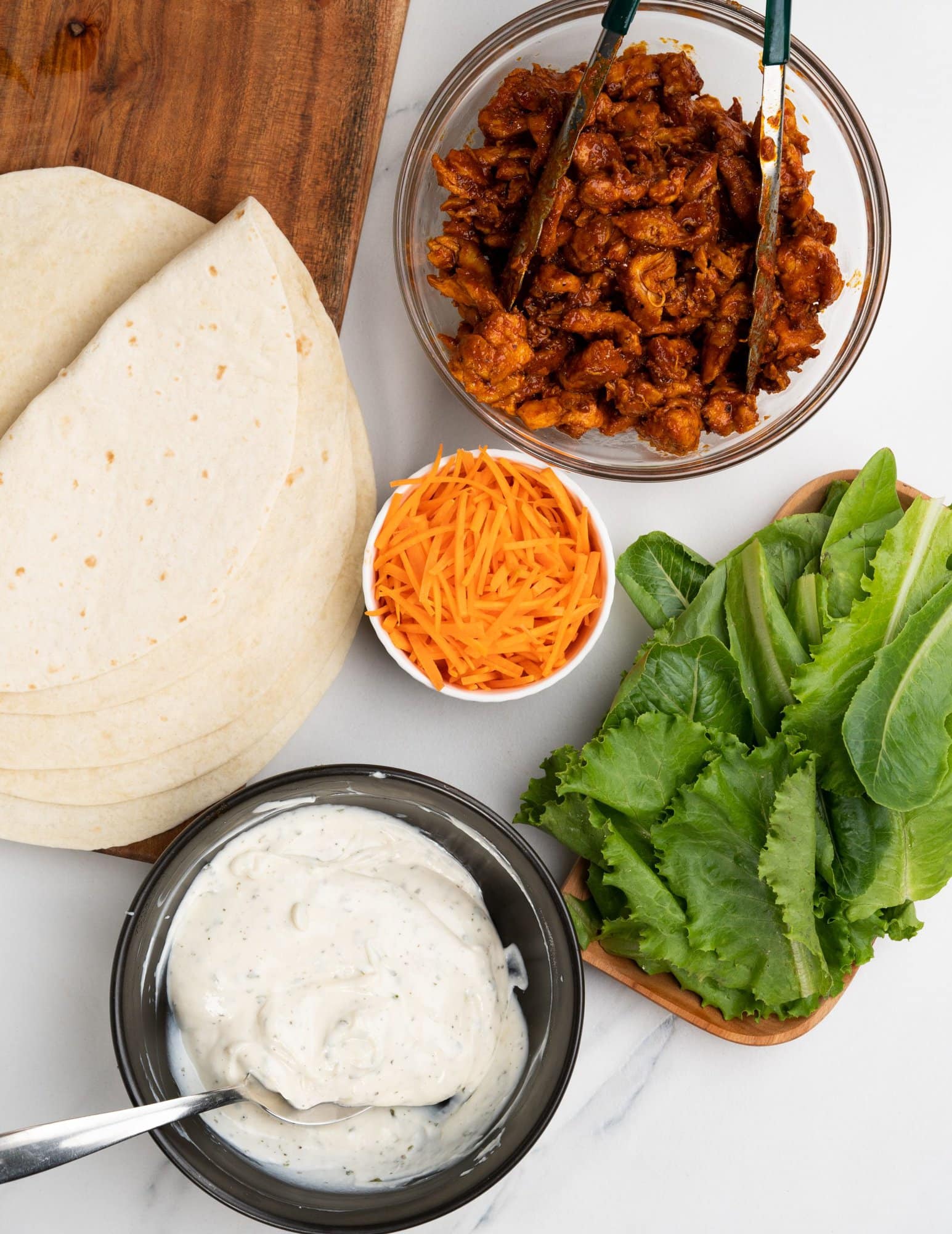 You need flour tortilla, spicy buffalo chicken filling, salad greens, carrots and creamy ranch dressing for buffalo chicken wrap. 
