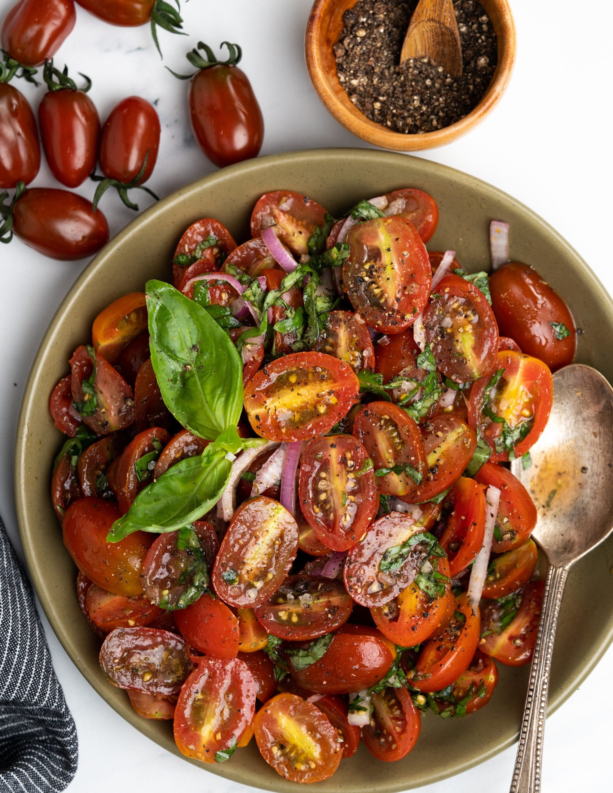 Plate of fresh cherry tomato salad with basil.