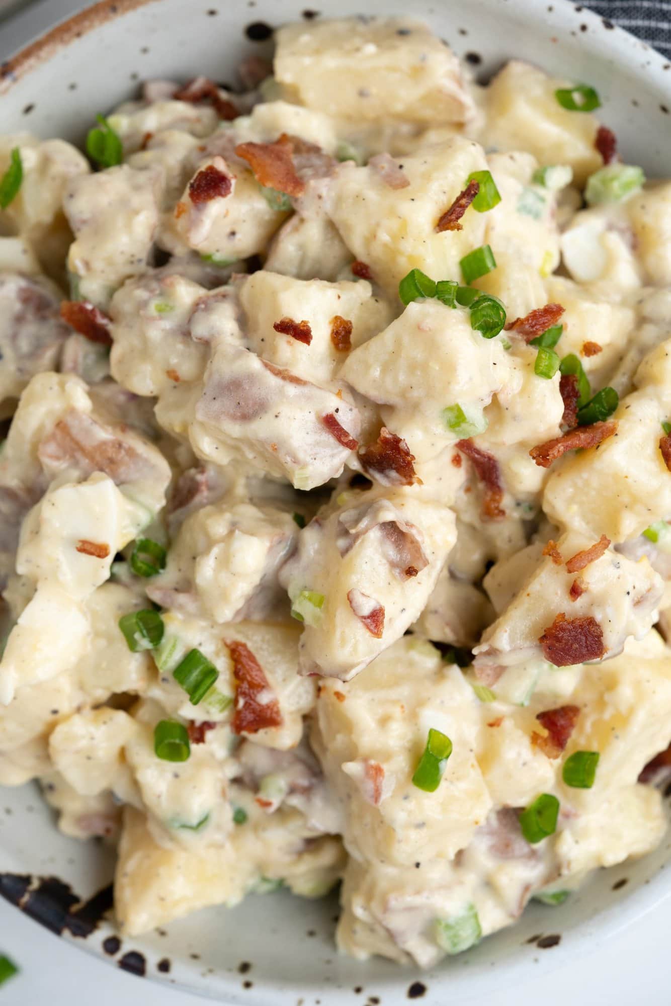 Red potato salad has green onion, celery, eggs , bacon and a creamy mayo dressing. 