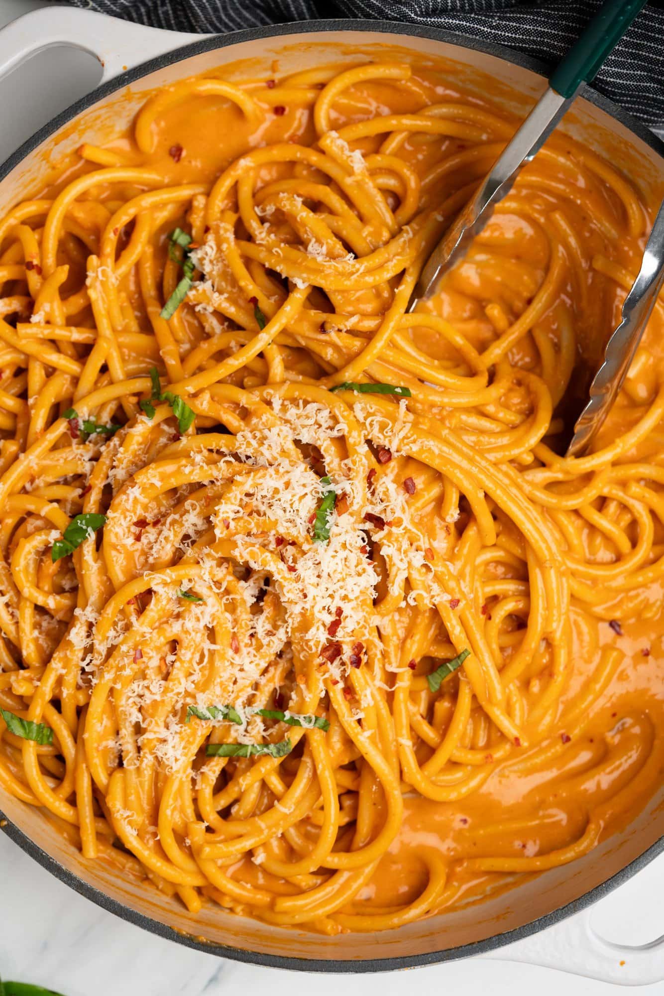 Saucy red bell pepper pasta with a creamy sauce and grated parmesan sprinkled on top.