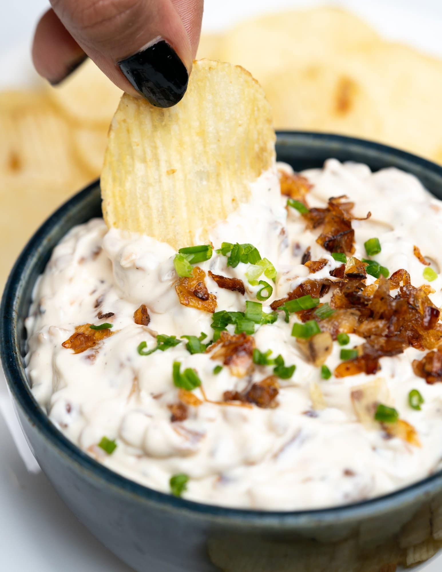 French onion dip garnished with chives and caramelized onion. Served with potato chips. 