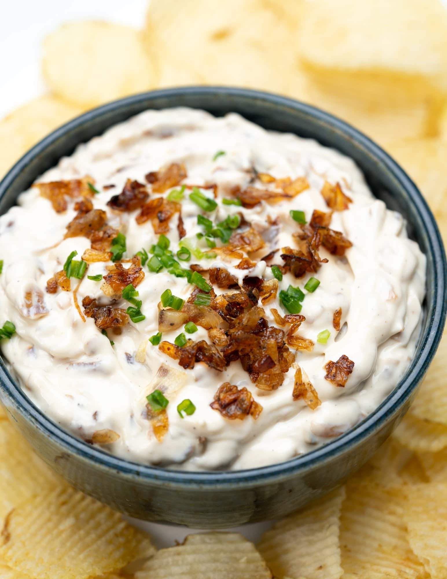 bowl of creamy homemade french onion dip with potato chips.