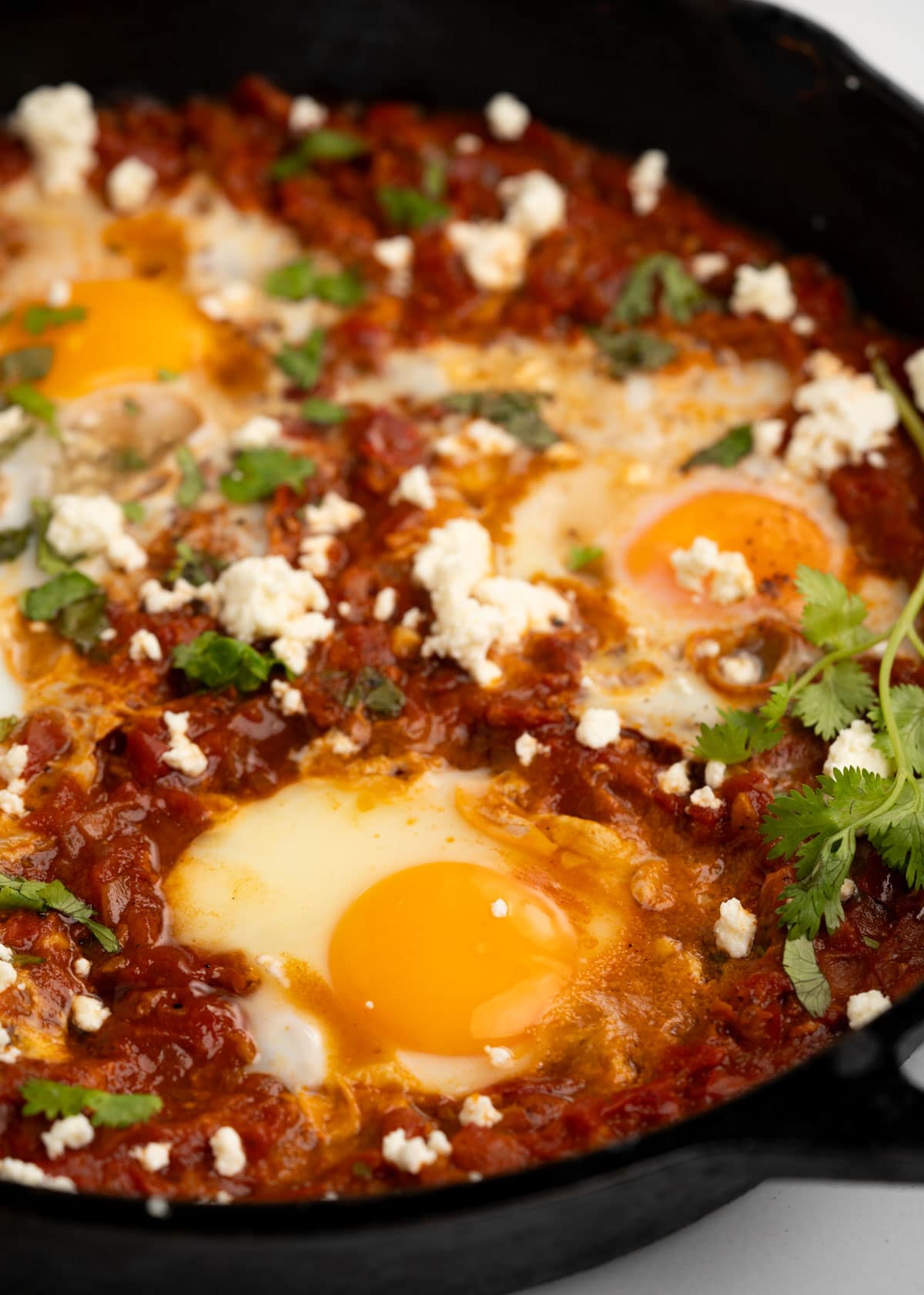 Eggs poached in spiced tomato sauce and topped with crumbled feta.