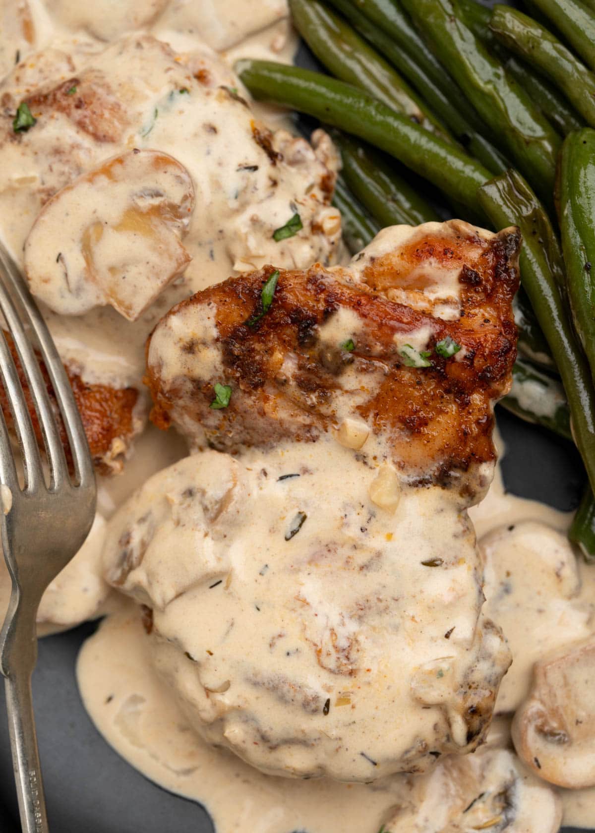 Crispy chicken thighs in a creamy mushroom sauce served with sauteed mushroom.