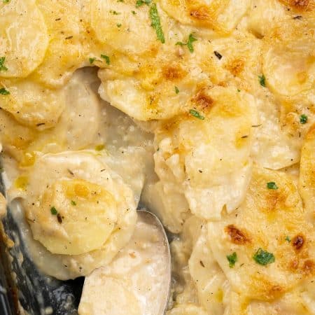 Creamy and cheesy sauce spooned from among potato slices with a golden crust on top