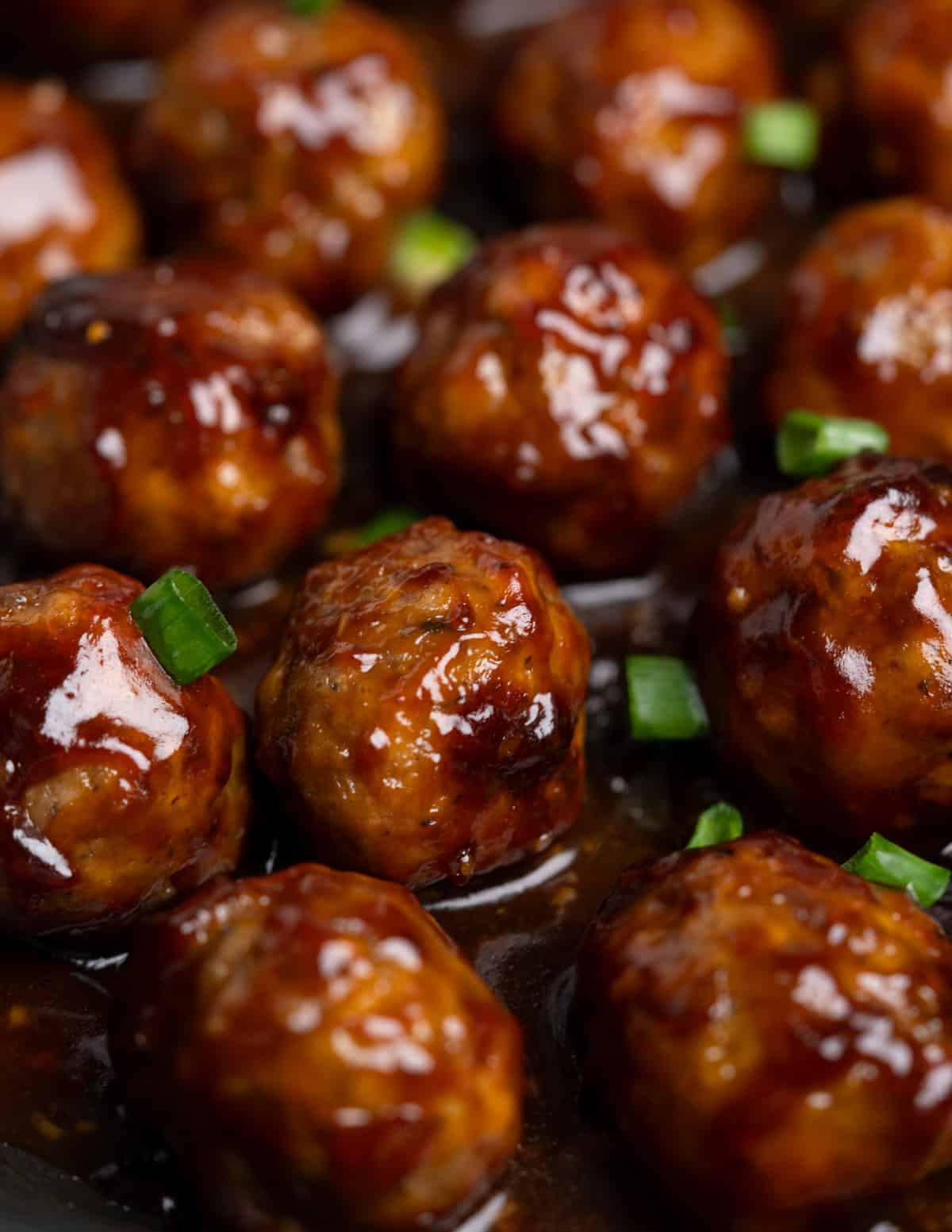 Close up of sweet and sour meatballs in a skillet. 