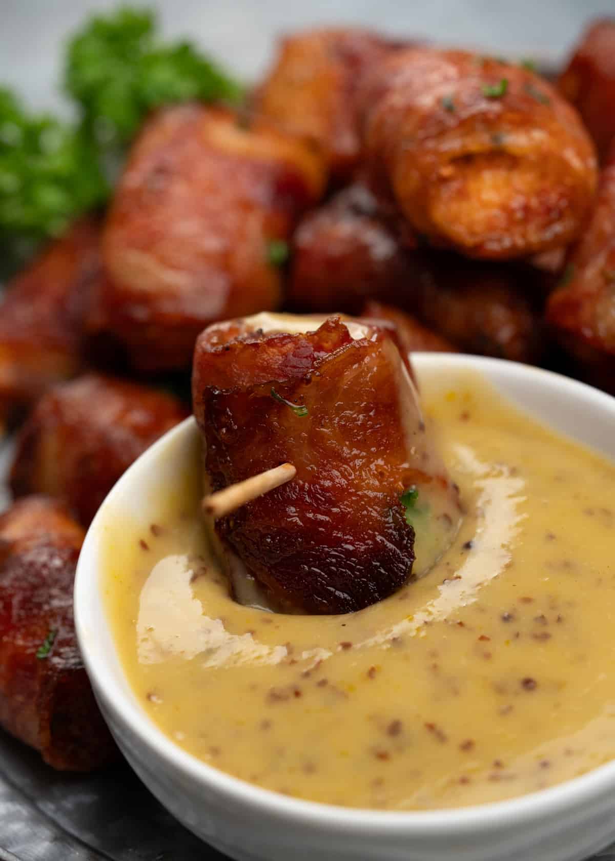 Bacon wrapped chicken bites dipped in honey mustard sauce
