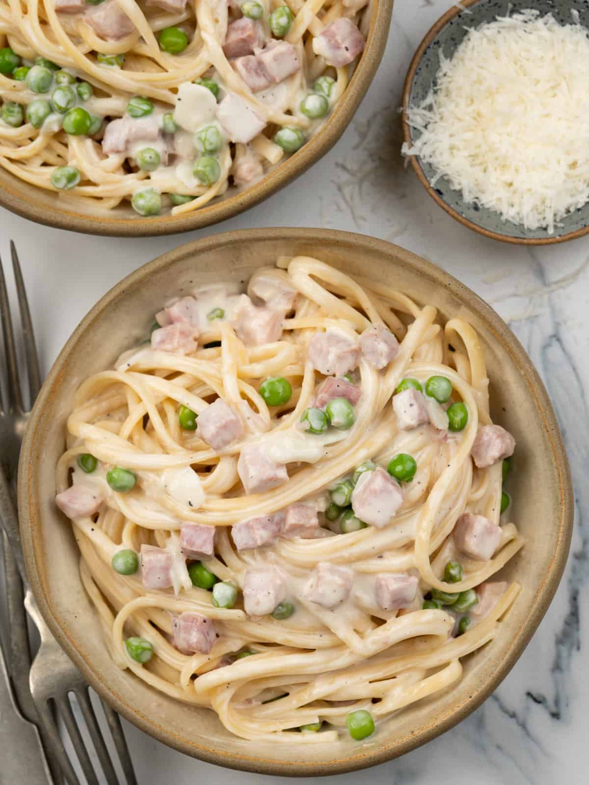Linguine pasta with ham and green peas in a garlic parmesan sauce.