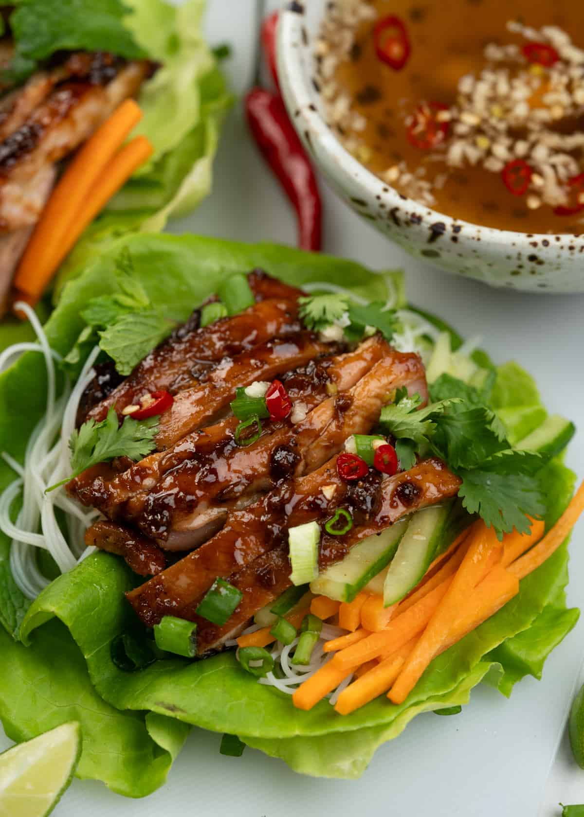 Tender lettuce leaves are topped with sweet sticky chicken, crunchy veggies, rice vermicelli, and fresh herbs and dressed with Nuoc Cham a salty, sweet, and spicy Vietnamese dipping sauce.