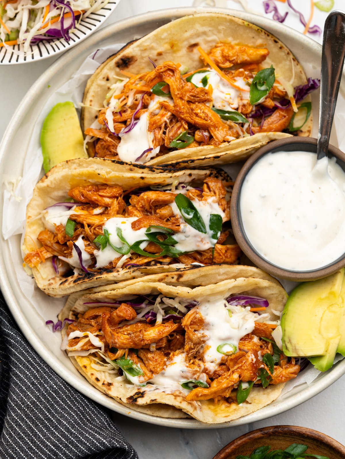 Delicious buffalo chicken tacos topped with ranch dressing and green onions