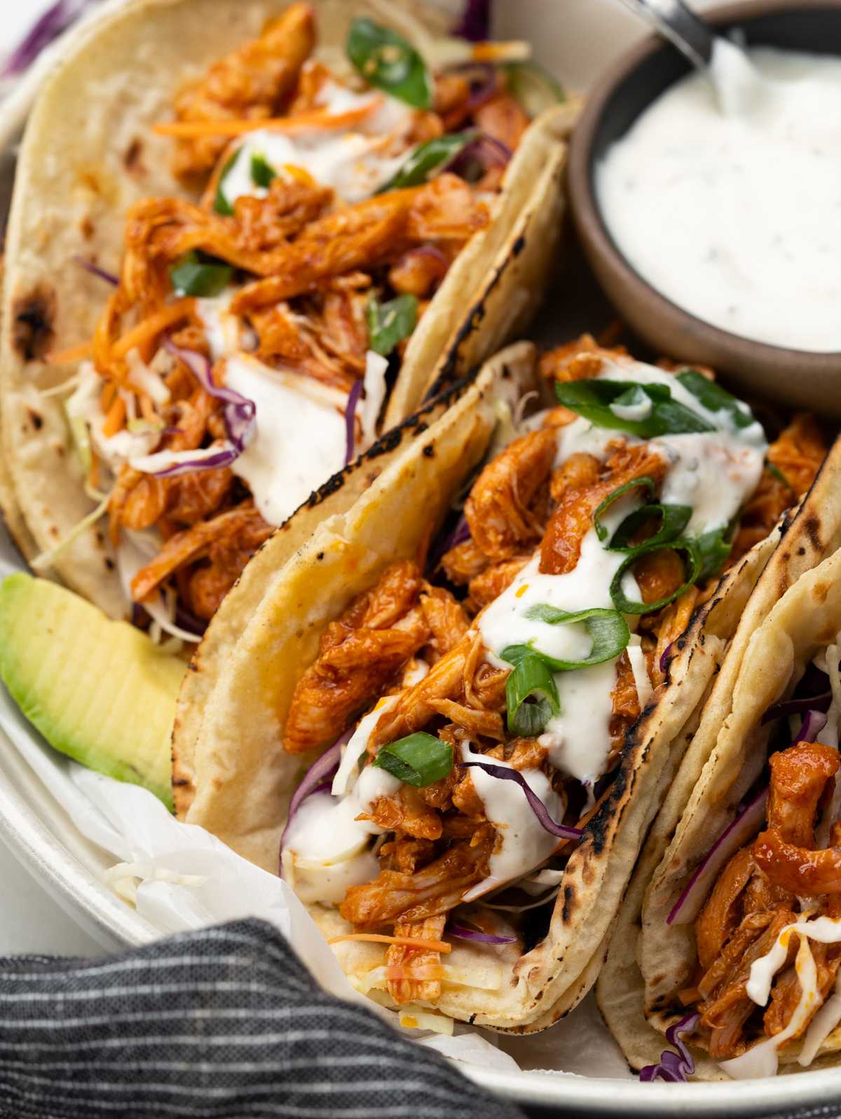 Delicious buffalo chicken tacos topped with ranch dressing and green onions