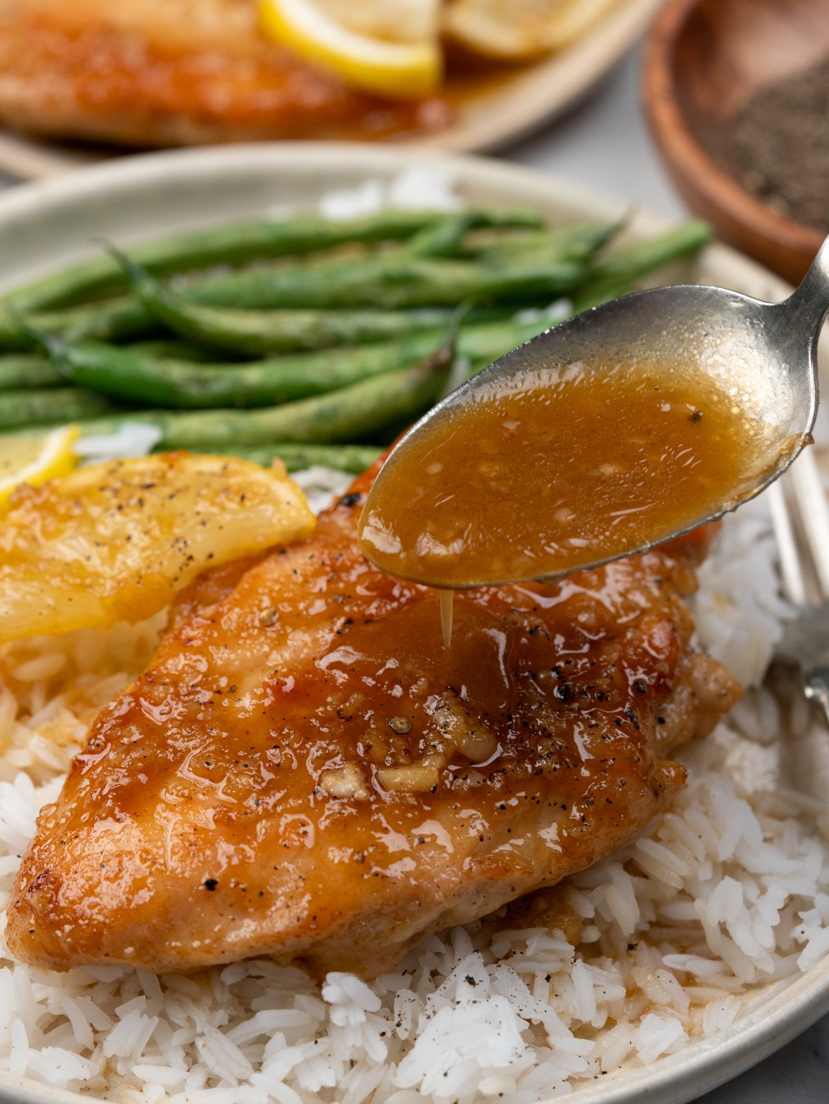 Serve Honey lemon sauce crispy chicken breast served over rice along with green beans.