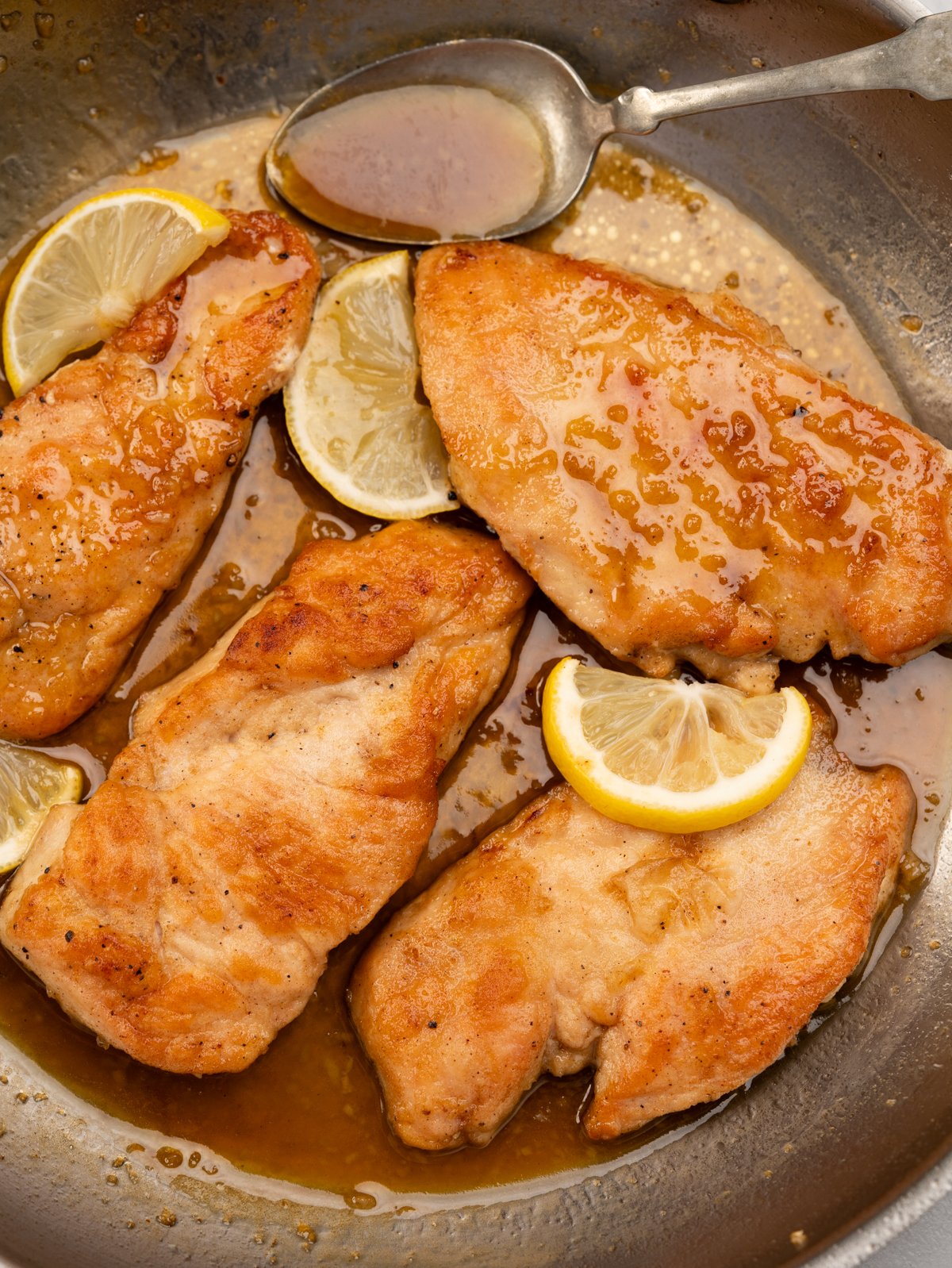Pan of Crispy panfried chicken coated in a sticky, sweet and tangy lemon honey sauce. 