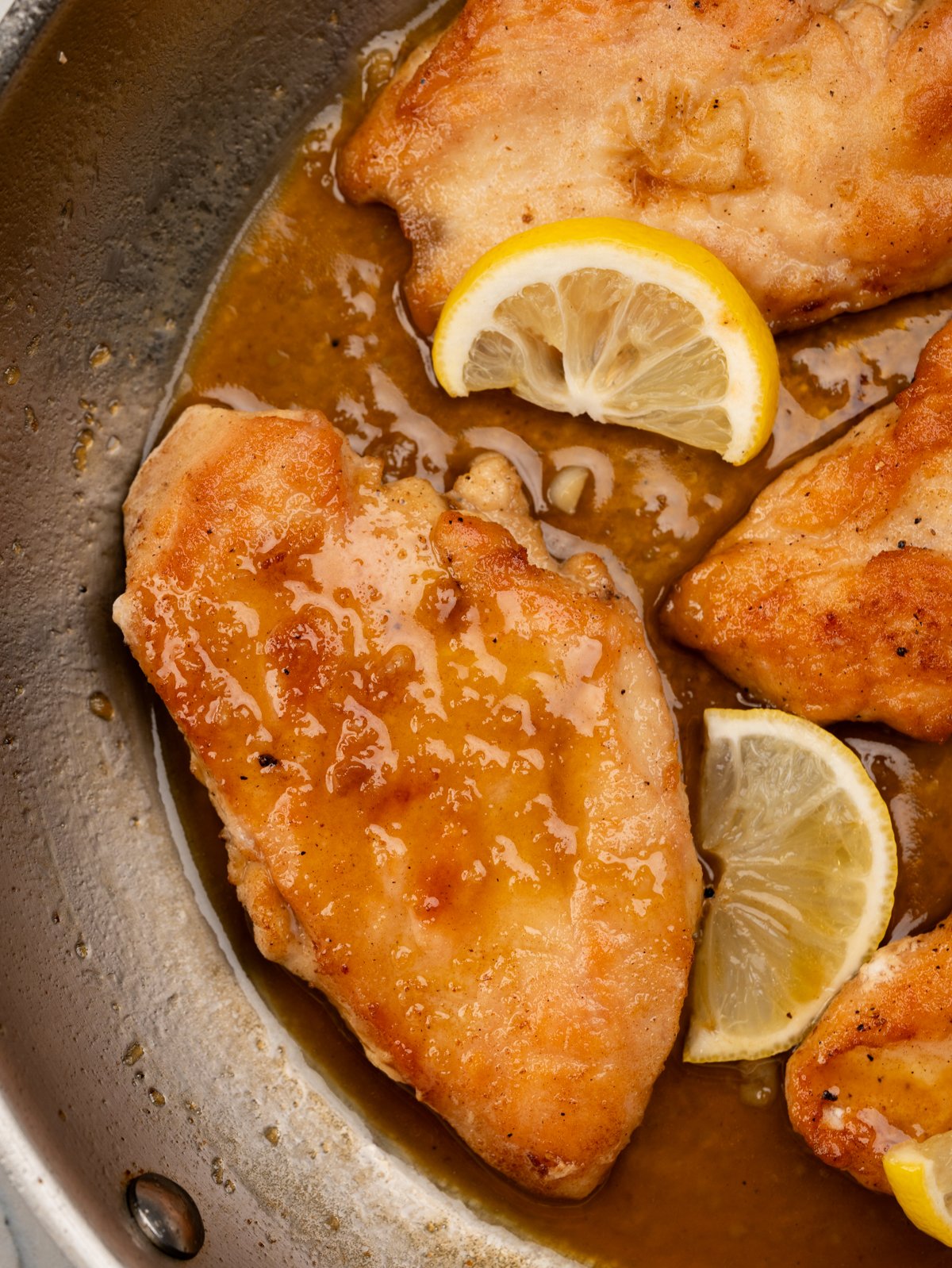 Pan of Crispy panfried chicken coated in a sticky, sweet and tangy lemon honey sauce. 