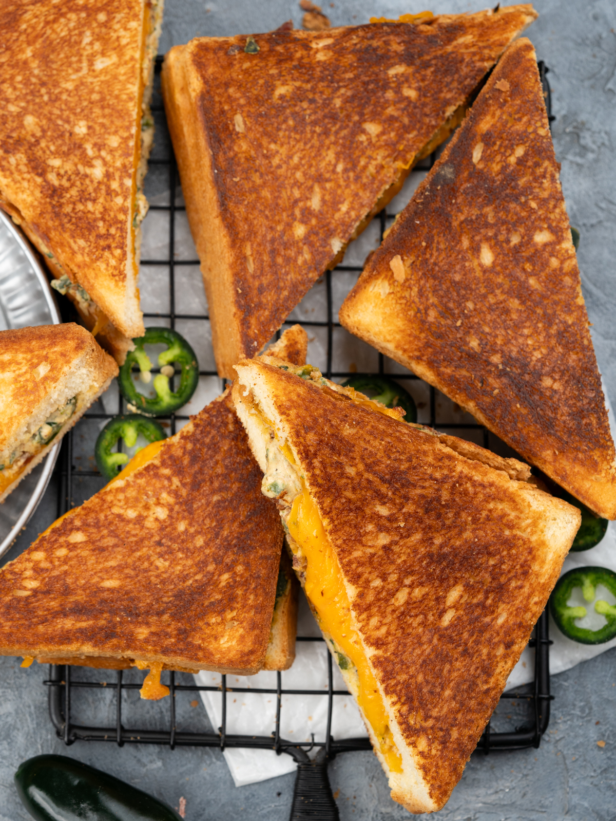 Jalapeno popper grilled cheese sandwiches placed on a cooling rack.