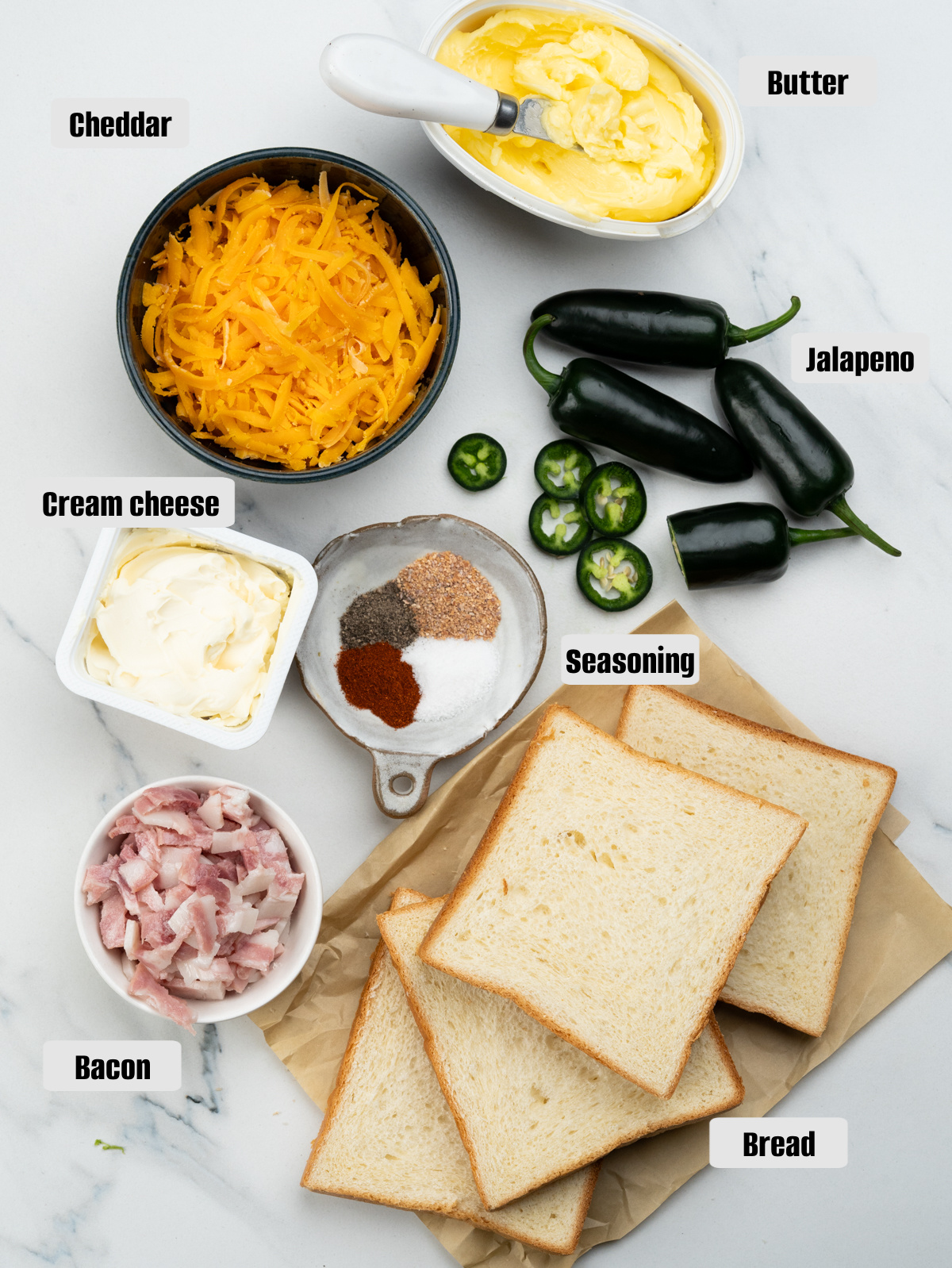 Ingredients displayed - Jalapenos, cream cheese, cheddar, bacon bits, bread, butter and seasoning.