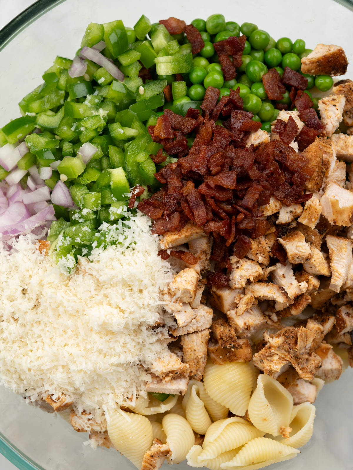 Shell pasta with diced grilled chicken, crispy bacon, peas, bell peppers, onion.