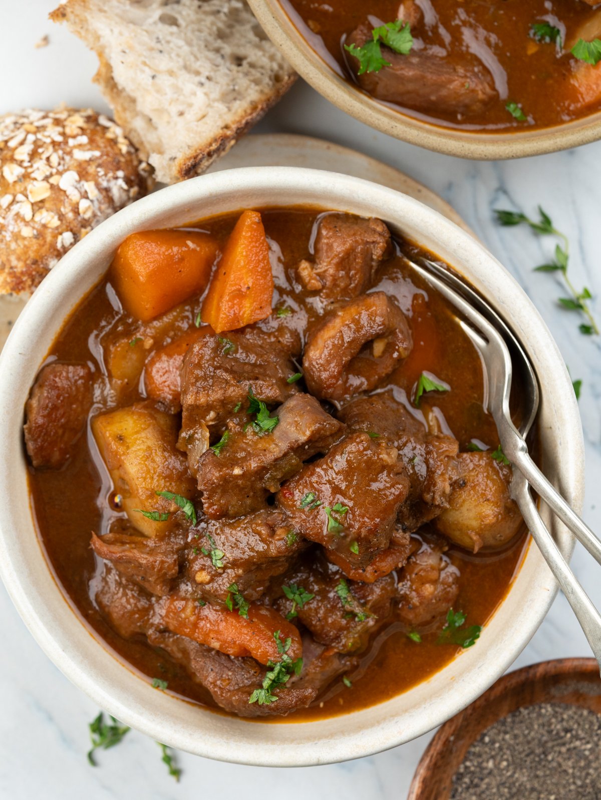 Slow-cooker lamb stew with tender, fall-apart lamb chunks, potatoes and carrot has a rustic flavourful thick broth served with bread. 