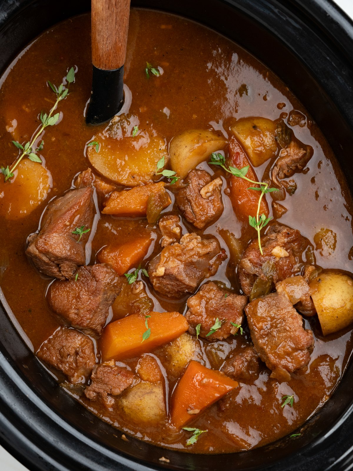 Slow-cooker lamb stew with tender, fall-apart lamb chunks, potatoes and carrot has a rustic flavourful thick broth