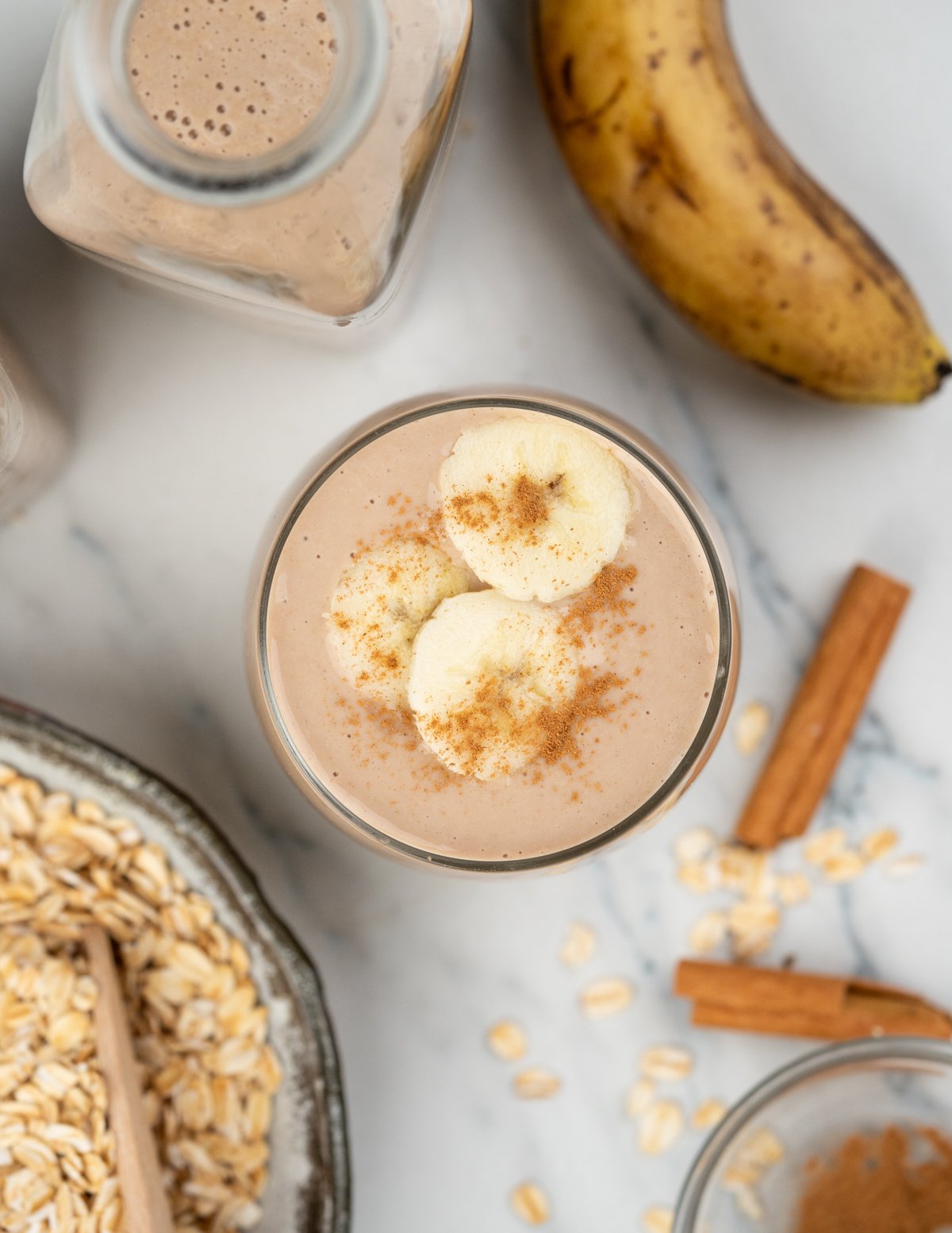 Creamy oatmeal banana smoothie served chiiled in a glass.